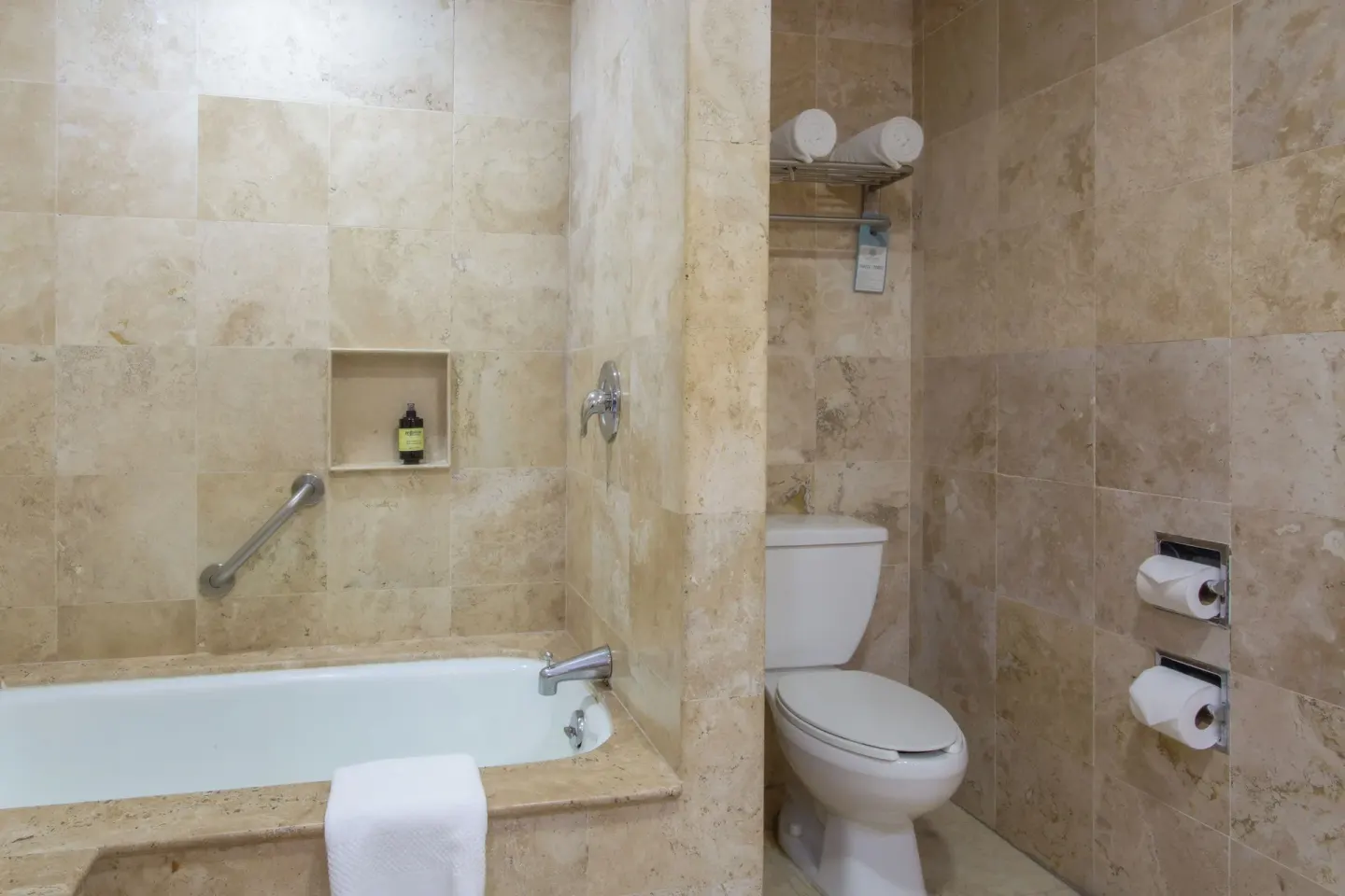 Deluxe Room bathroom with bathtub and toilet at Sandos Cancún.