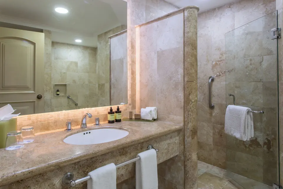 Deluxe Room bathroom vanity and glass shower at Sandos Cancún.