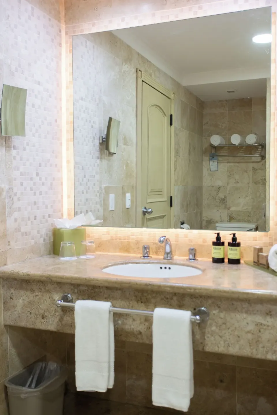 Deluxe Room bathroom vanity with mirror and towels at Sandos Cancún.