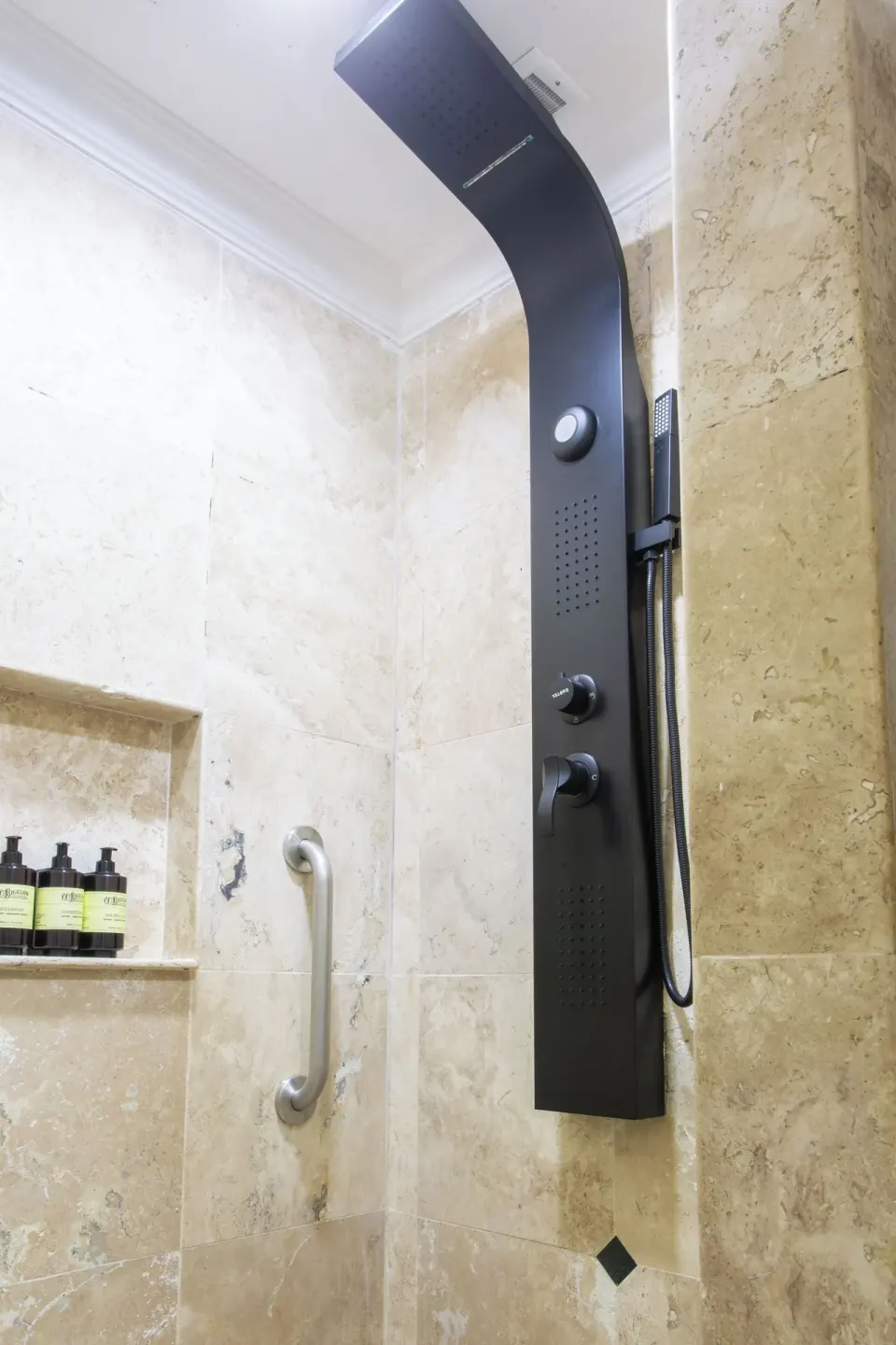 Laguna Suite bathroom shower with black shower panel, grab bar, and bath amenities at Sandos Cancún.