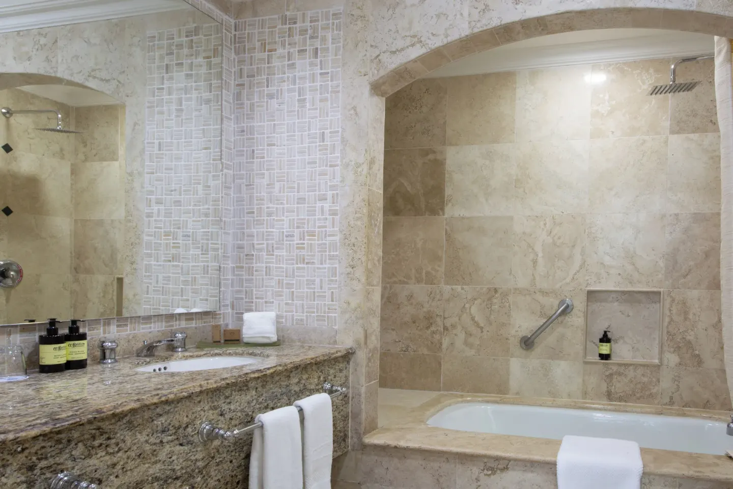 Sandos Cancún bathroom with vanity, mirror, soaking tub, and walk-in shower at Sandos Cancún.