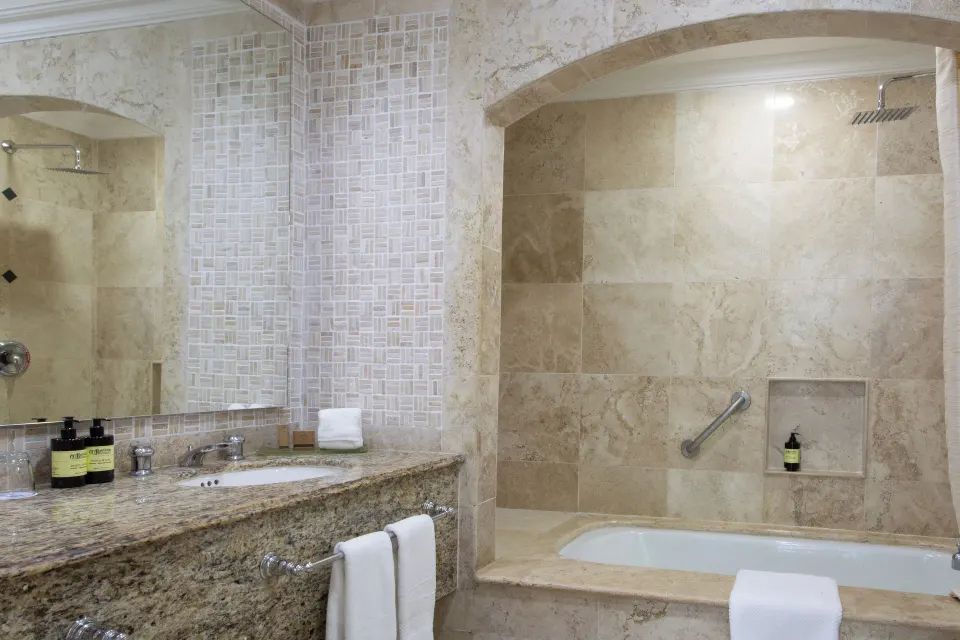 Sandos Cancún bathroom with vanity, mirror, soaking tub, and walk-in shower at Sandos Cancún.