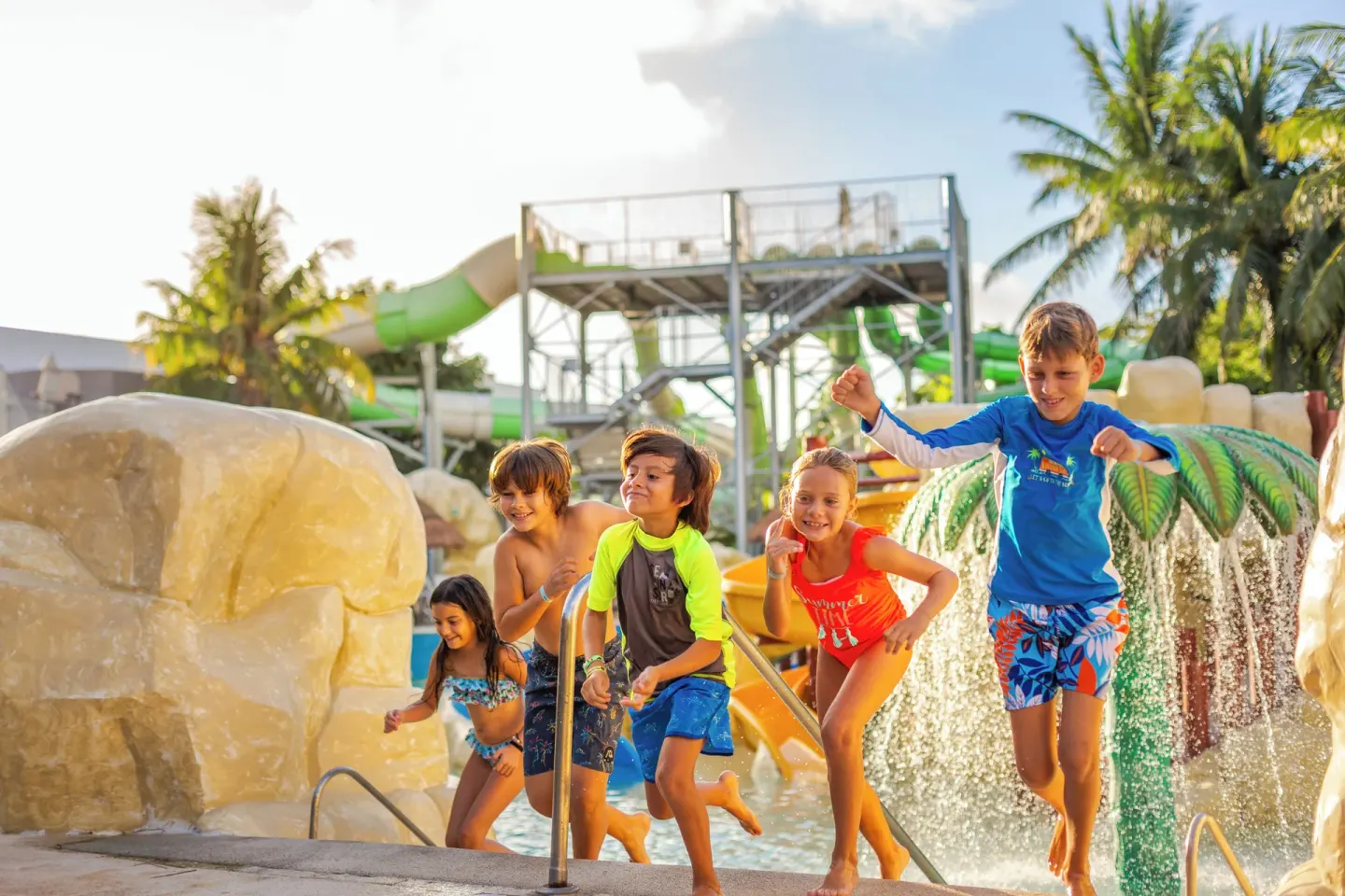 Children run past water features at the splash park at Sandos Caracol Nature Resort & Water Park.