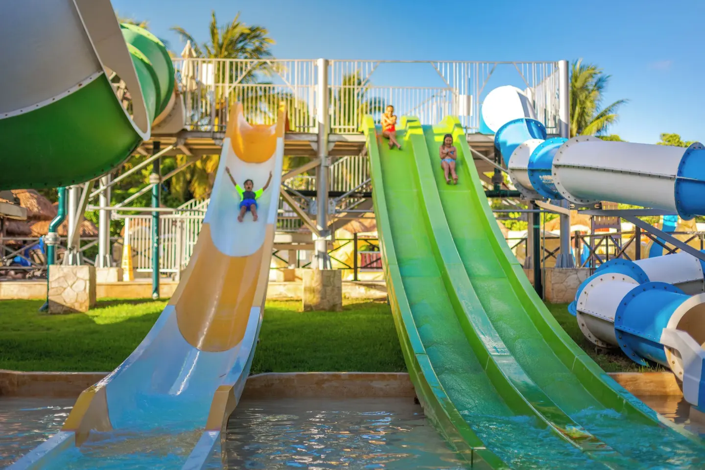 Children ride colorful open slides at Sandos Caracol Nature Resort & Water Park.