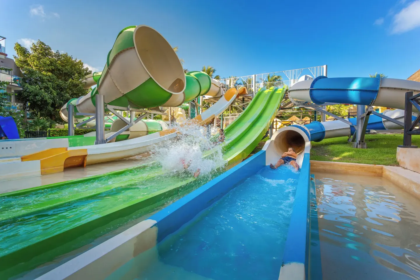 Guests splash down colorful water slides at Sandos Caracol Nature Resort & Water Park.