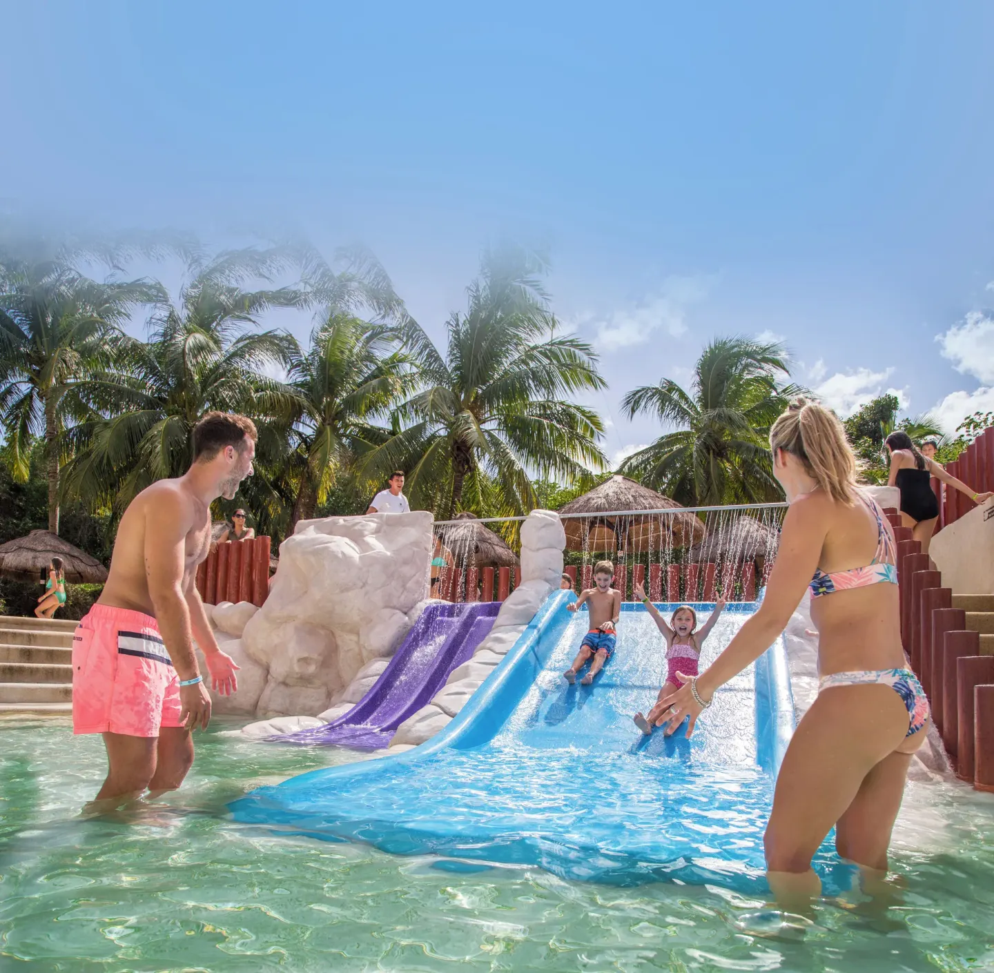 Families play on small pool slides at Sandos Caracol Nature Resort & Water Park.