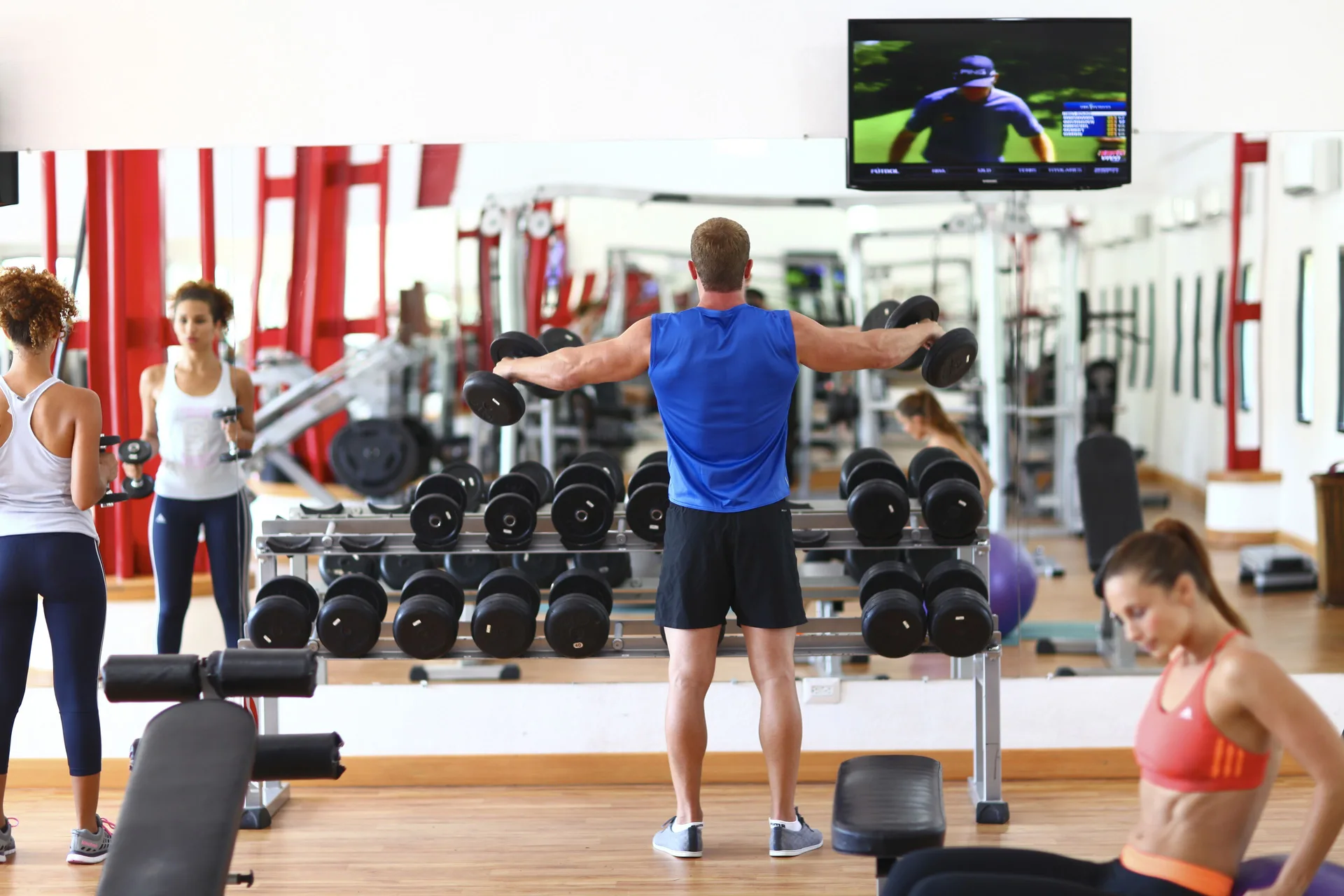 Guests lifting dumbbells in the fitness center at Sandos Caracol Nature Resort & Water Park.