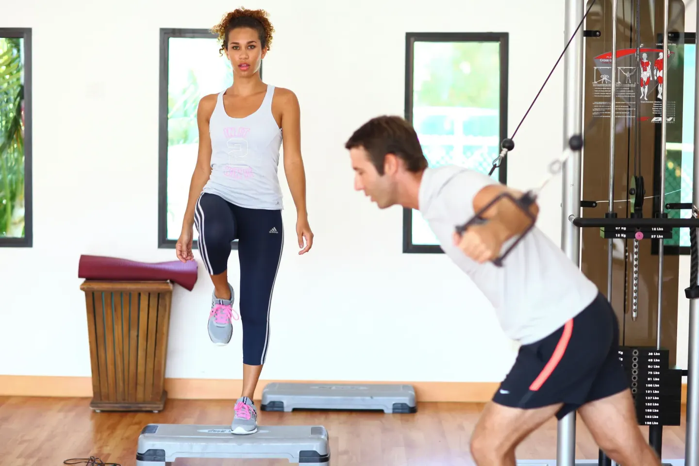 Guests exercising with a step platform and cable machine at Sandos Caracol Nature Resort & Water Park.