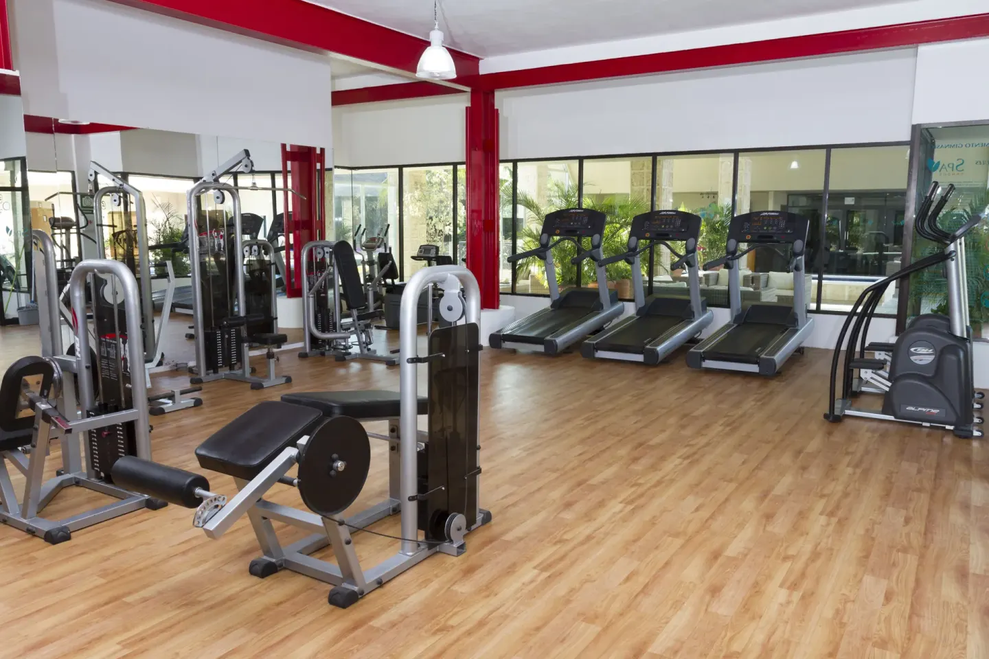 Fitness room with cardio and weight machines at Sandos Caracol Nature Resort & Water Park.