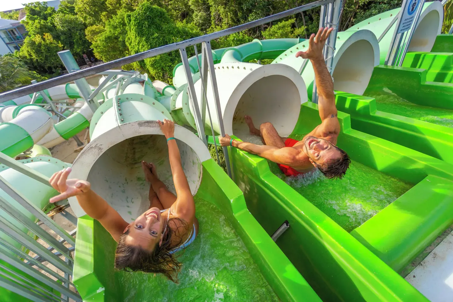 Two guests start down green tube slides at Sandos Caracol Nature Resort & Water Park.