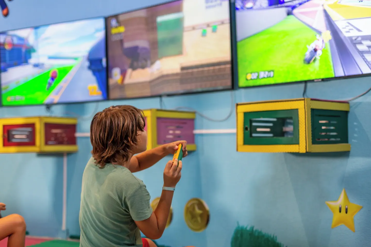 Child playing video games in a kids area at Sandos Caracol Nature Resort & Water Park.