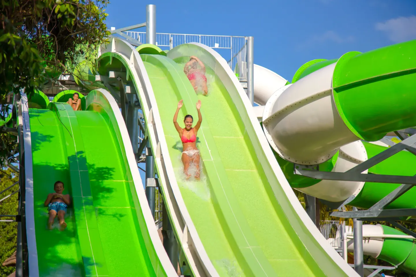 Riders descend side-by-side green water slides at Sandos Caracol Nature Resort & Water Park.