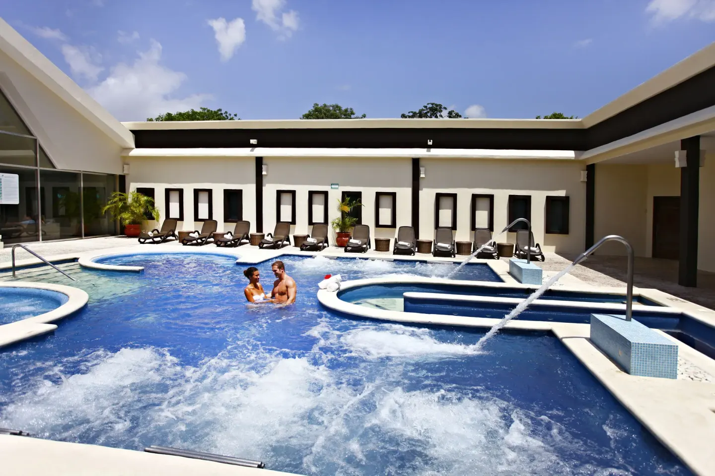 Spa-style pool with loungers and water features at Sandos Caracol Nature Resort & Water Park.