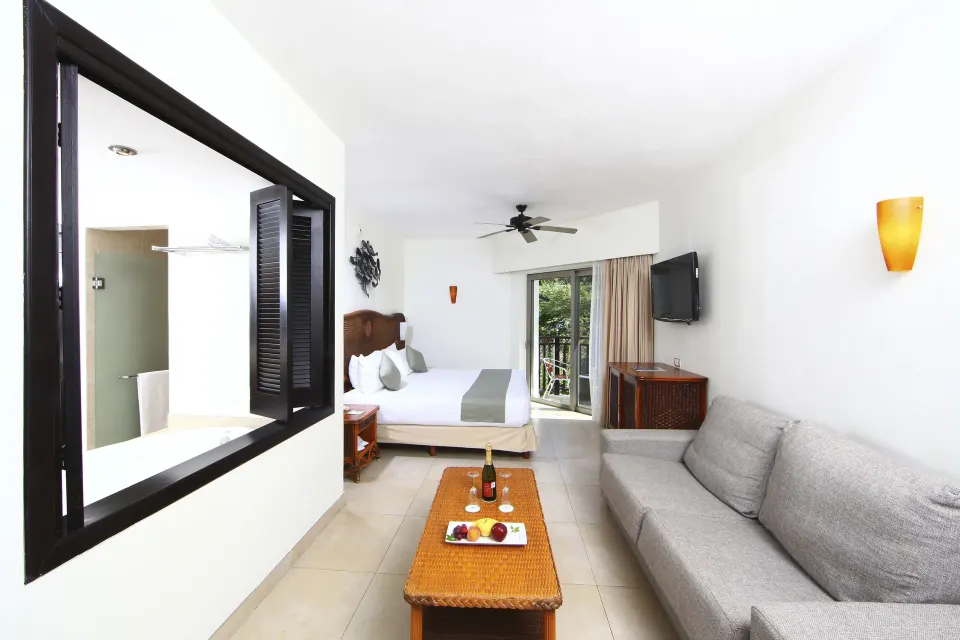Deluxe Select adults-only room with king bed and sofa at Sandos Caracol Nature Resort & Water Park.
