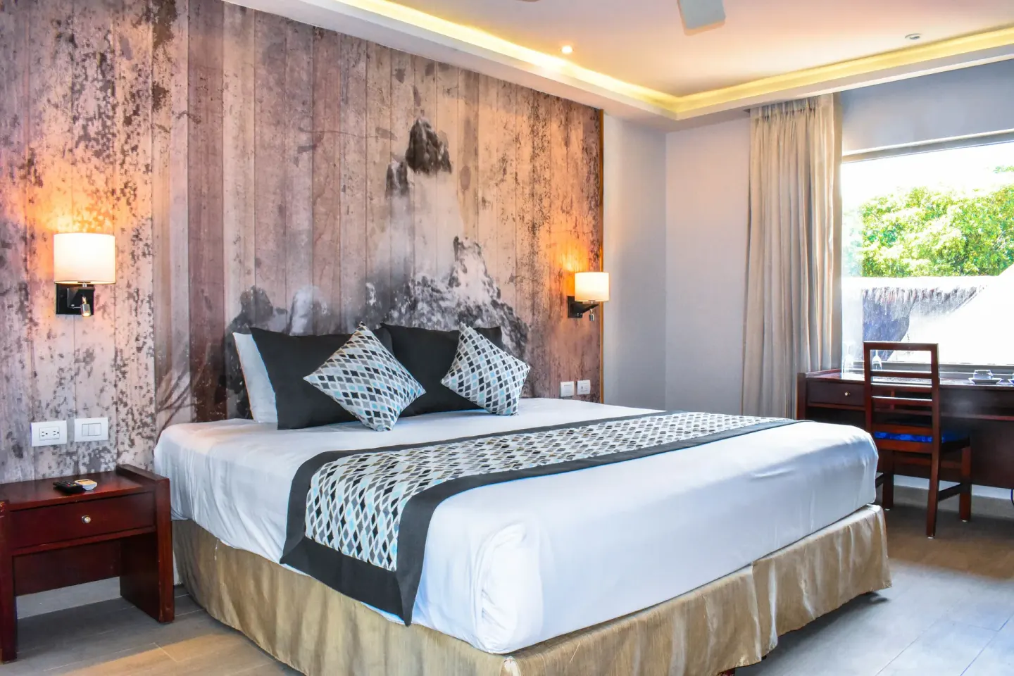 Eco Junior Suite king bed and desk at Sandos Caracol Nature Resort & Water Park.