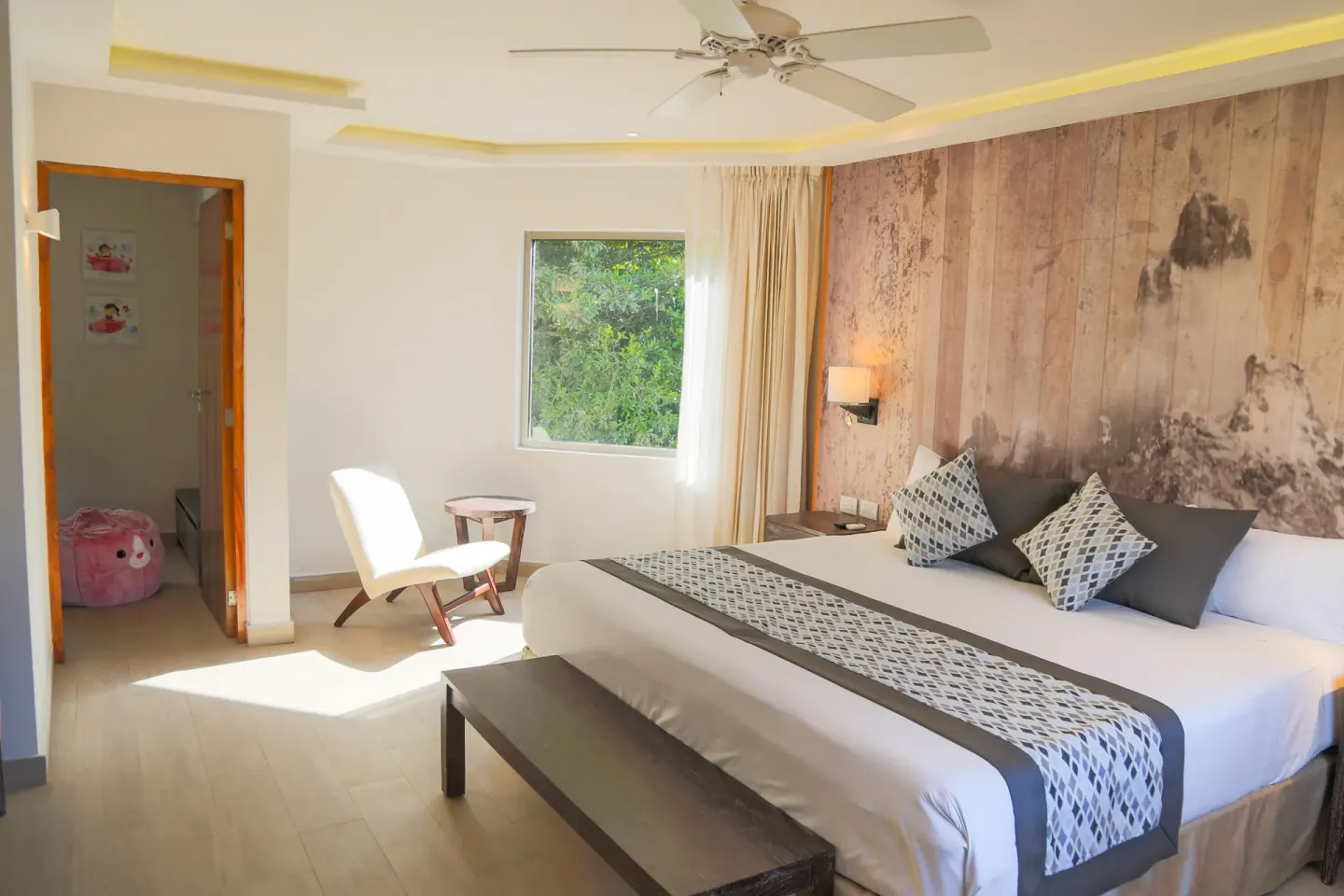 Eco Junior Suite king bed and seating area at Sandos Caracol Nature Resort & Water Park.
