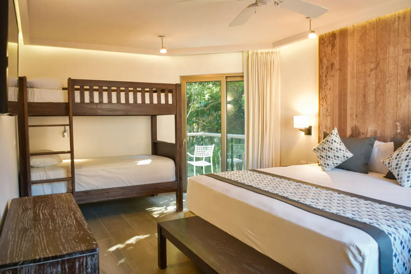 Eco Family Superior king bed, bunk beds, and balcony at Sandos Caracol Nature Resort & Water Park.