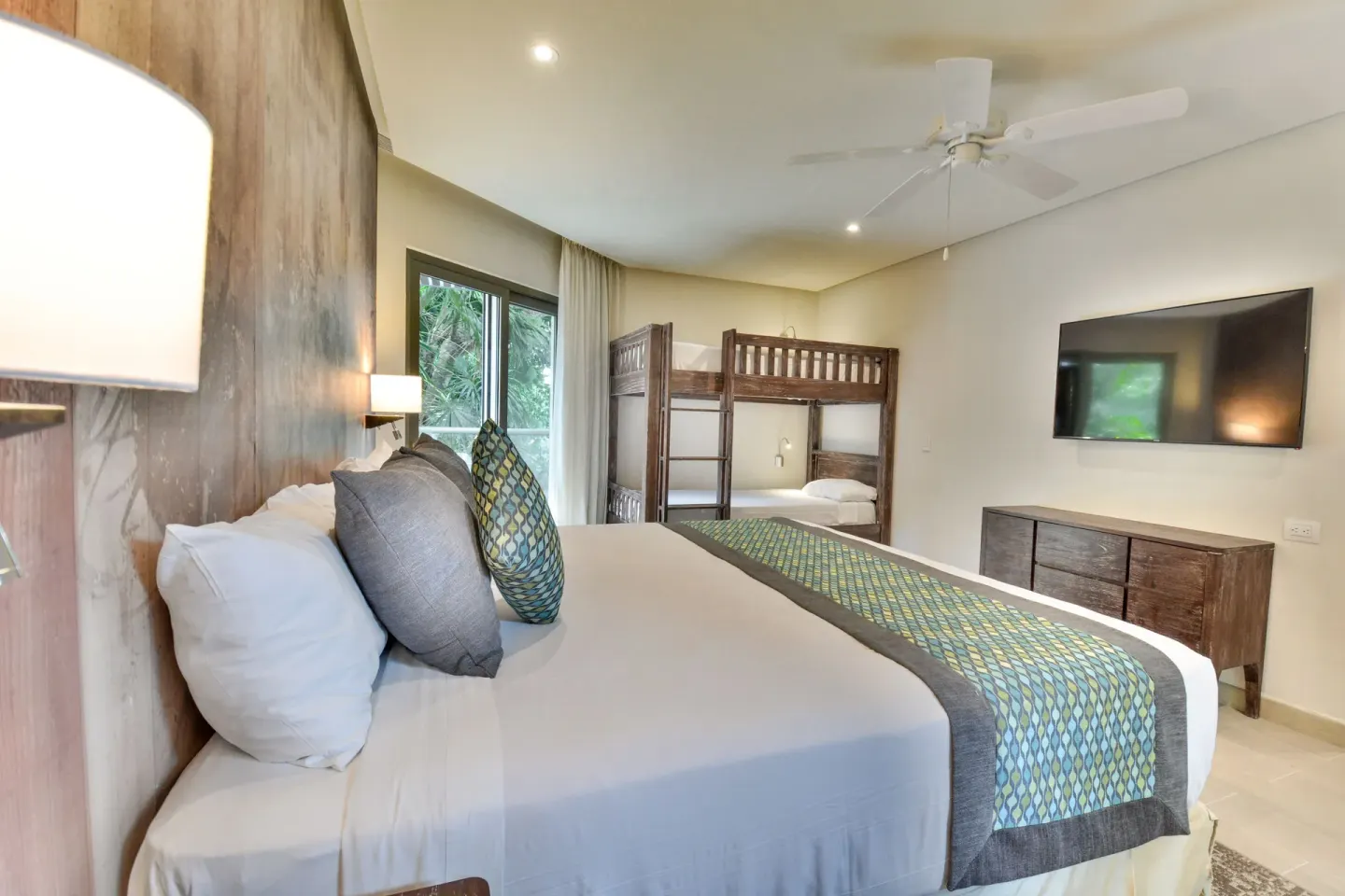 Eco Family Superior king bed with bunk beds and TV at Sandos Caracol Nature Resort & Water Park.