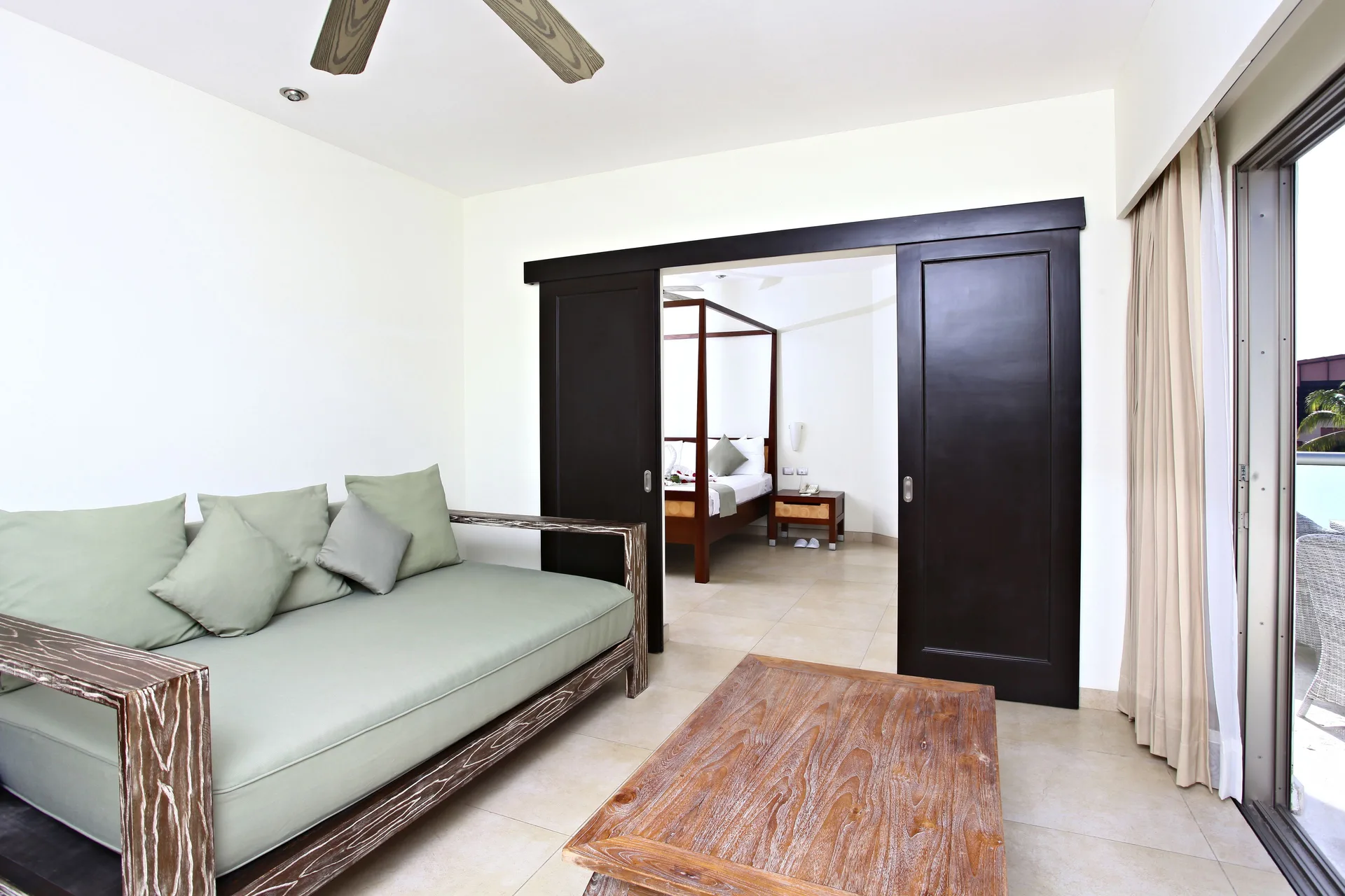 Penthouse Select sitting area with daybed and bedroom beyond at Sandos Caracol Nature Resort & Water Park.