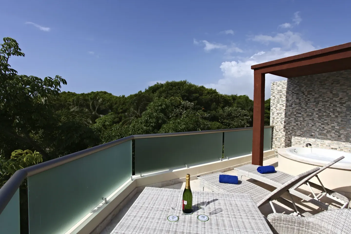 Penthouse Select terrace with loungers, whirlpool tub, and treetop view at Sandos Caracol Nature Resort & Water Park.