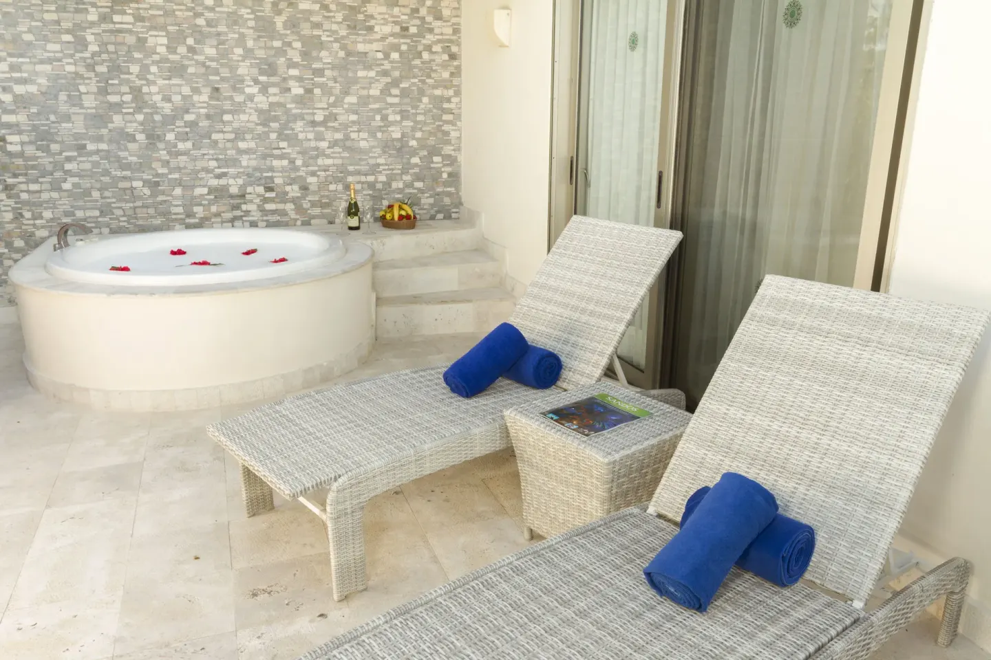 Penthouse Select terrace with loungers and round whirlpool tub at Sandos Caracol Nature Resort & Water Park.