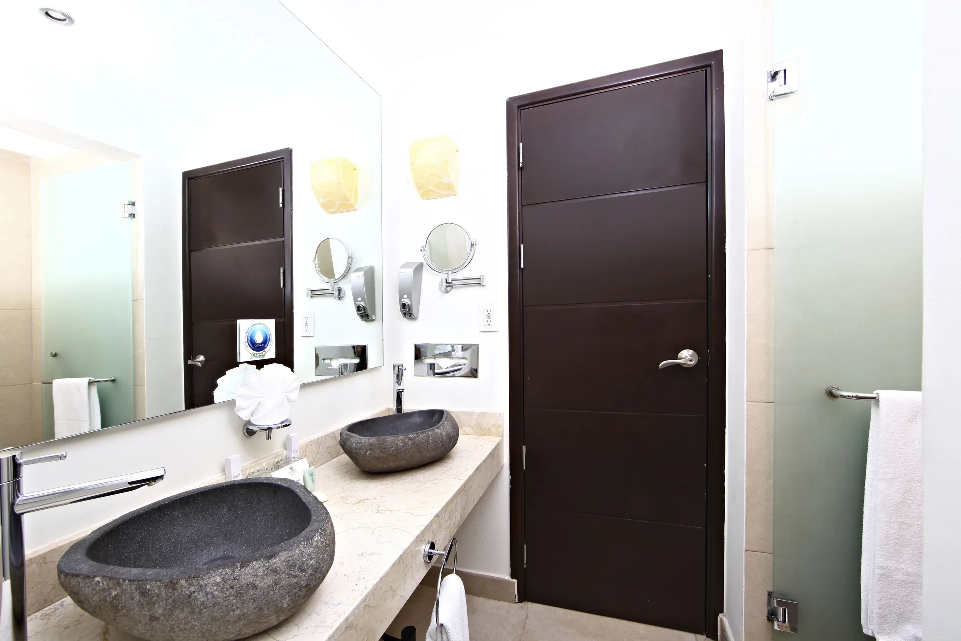 Pool View Penthouse bathroom with stone vessel sinks at Sandos Caracol Nature Resort & Water Park.