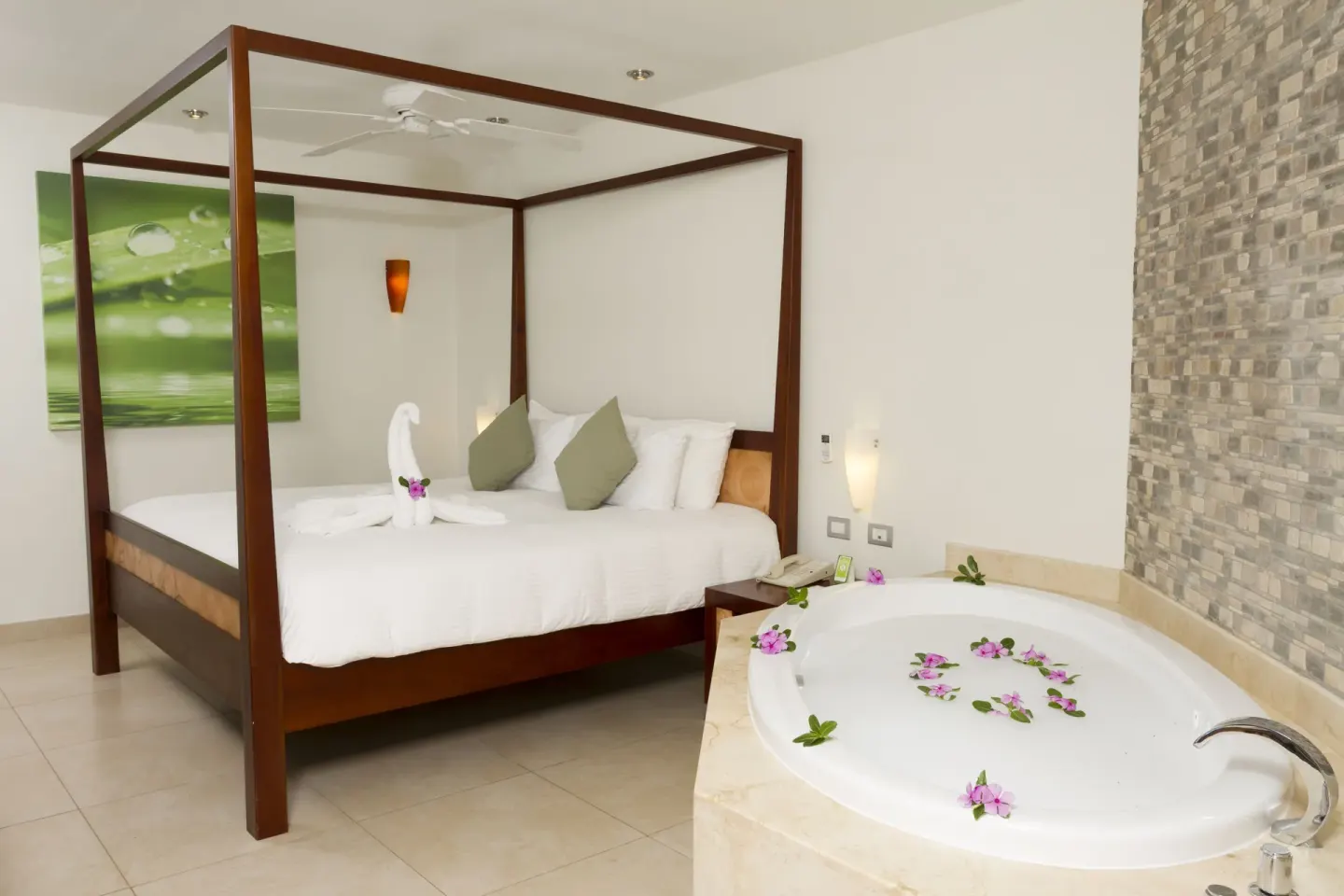 Pool View Penthouse bedroom with canopy bed and round tub at Sandos Caracol Nature Resort & Water Park.