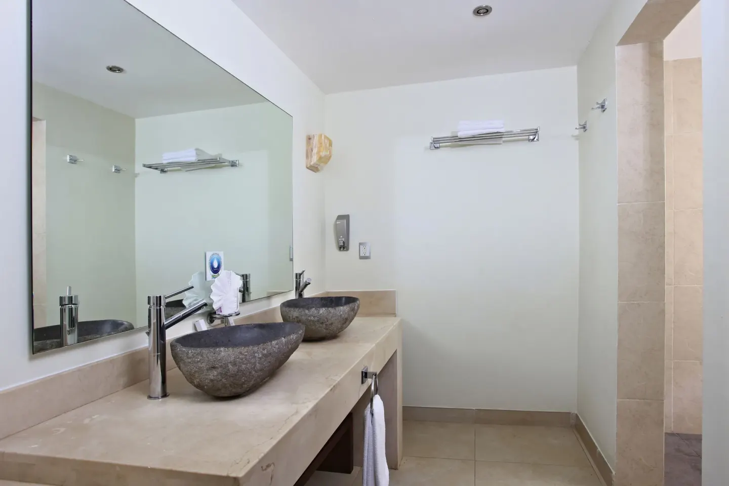Pool View Superior bathroom vanity and shower entrance at Sandos Caracol Nature Resort & Water Park.