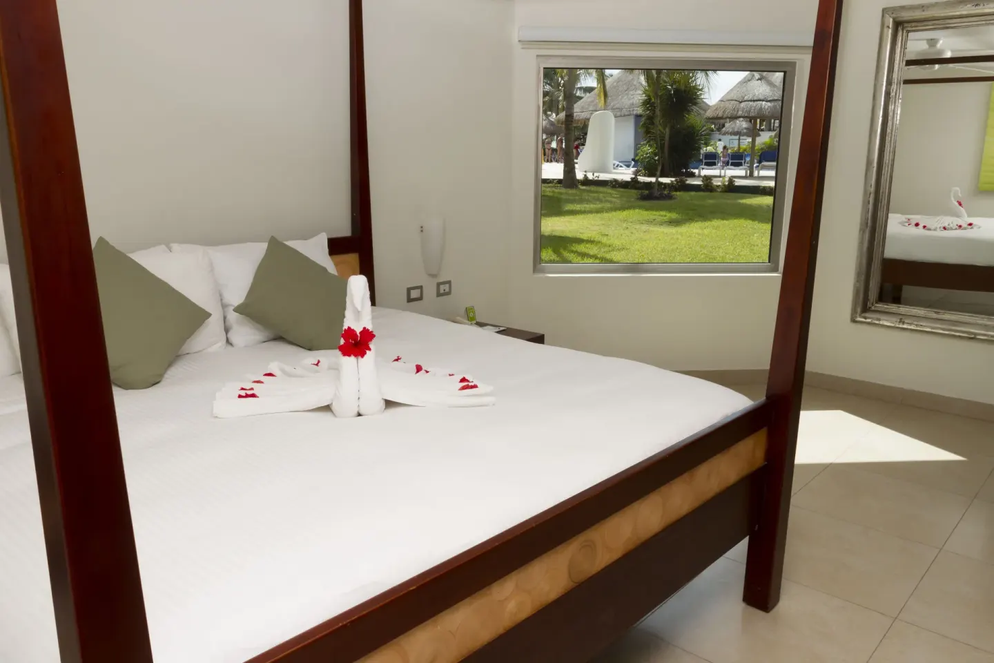 Pool View Superior four-poster bed and window at Sandos Caracol Nature Resort & Water Park.