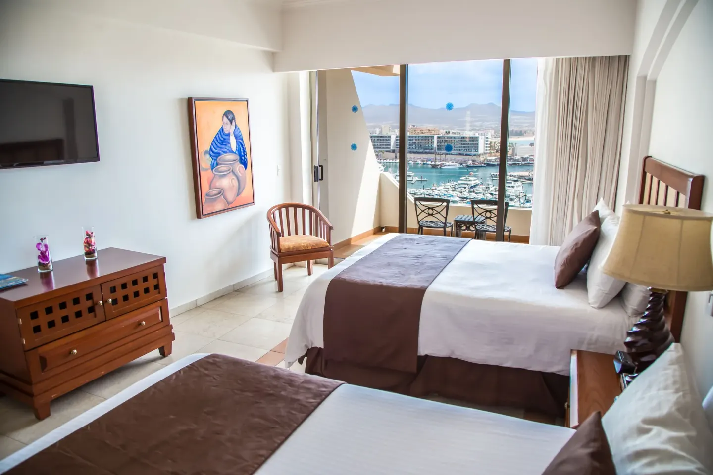 Guest room with two beds and a marina-view balcony at Sandos Finisterra.