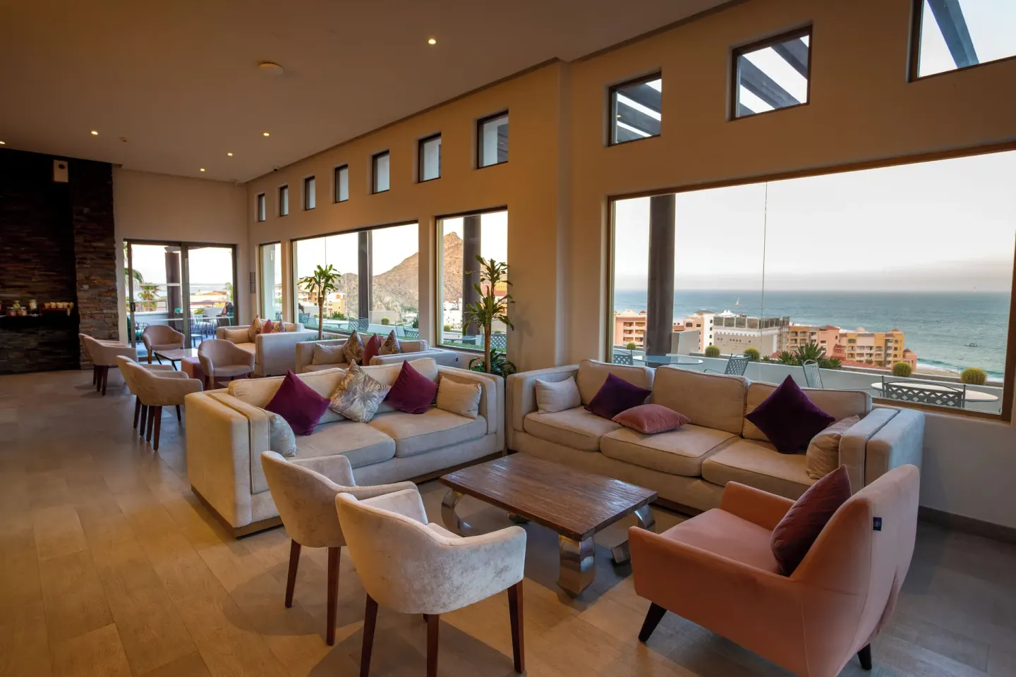 Lounge with sofas, large windows, and ocean views at Sandos Finisterra.