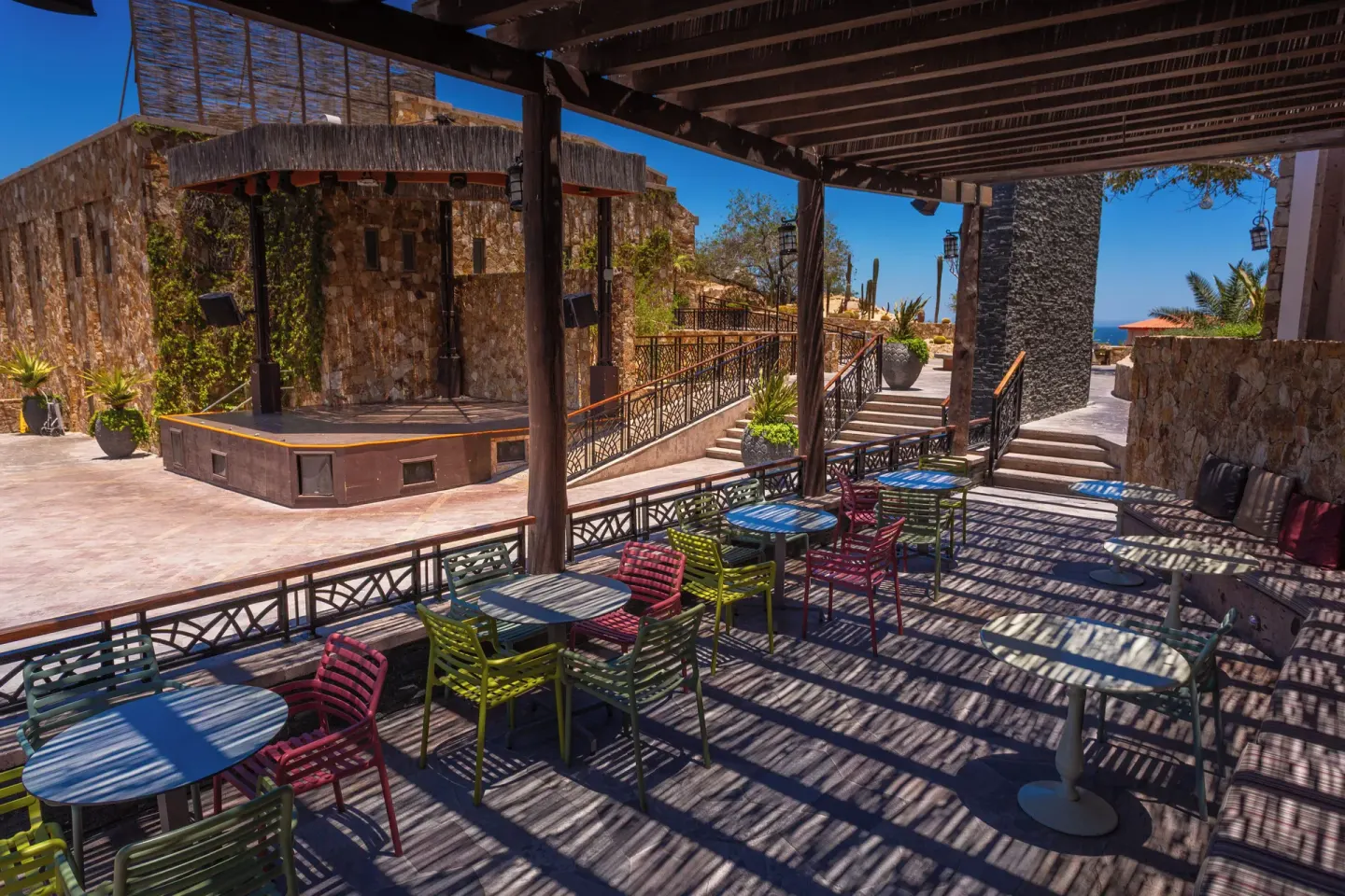 Shaded terrace seating facing an outdoor stage at Sandos Finisterra.