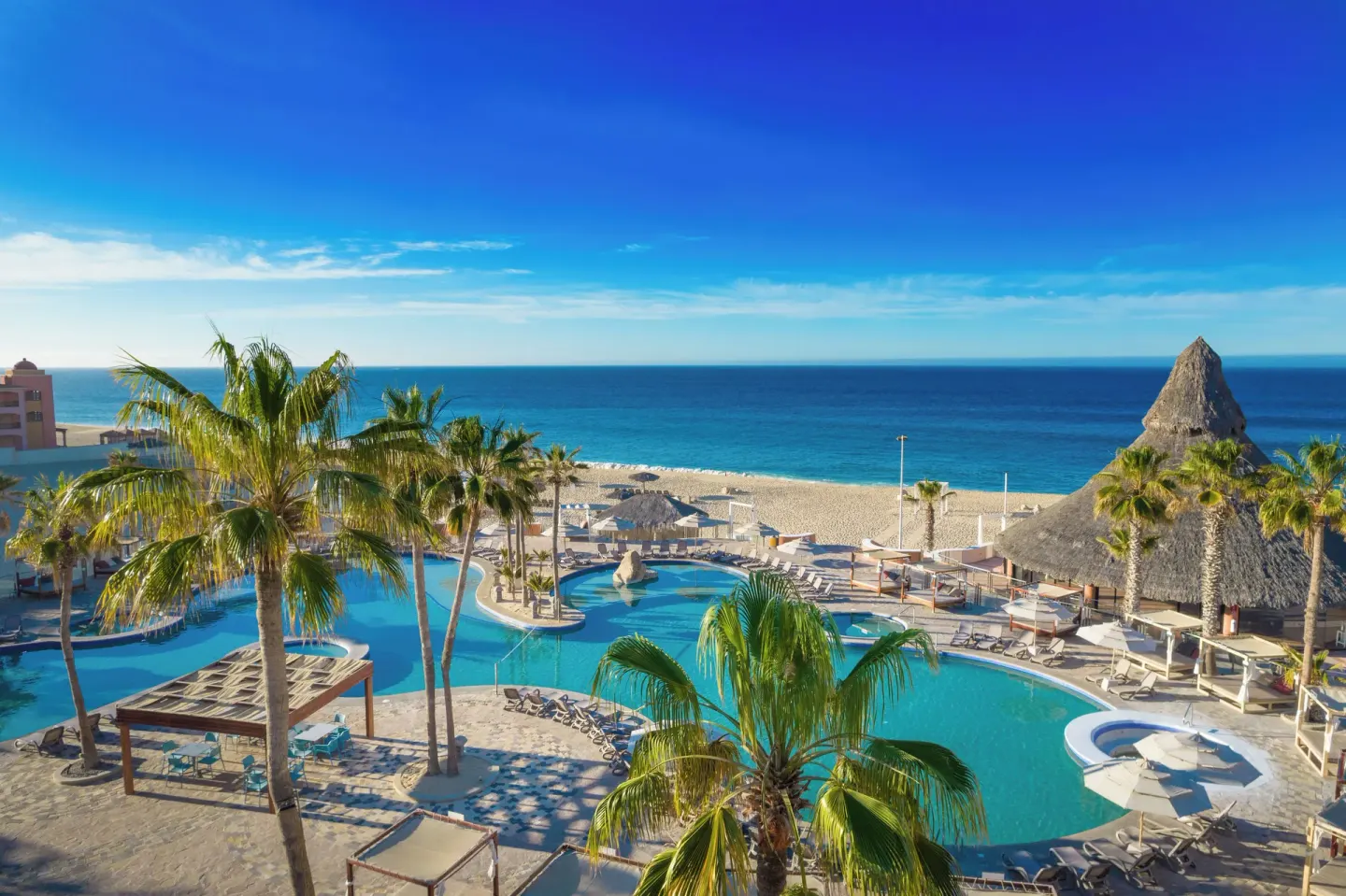 Pools, palms, beach, and ocean viewed from above at Sandos Finisterra.