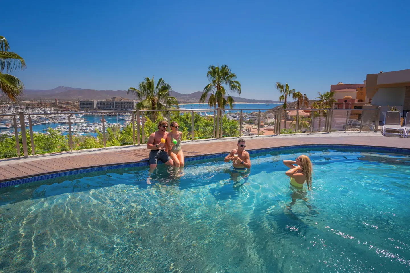 Guests relax in an upper pool overlooking the marina at Sandos Finisterra.