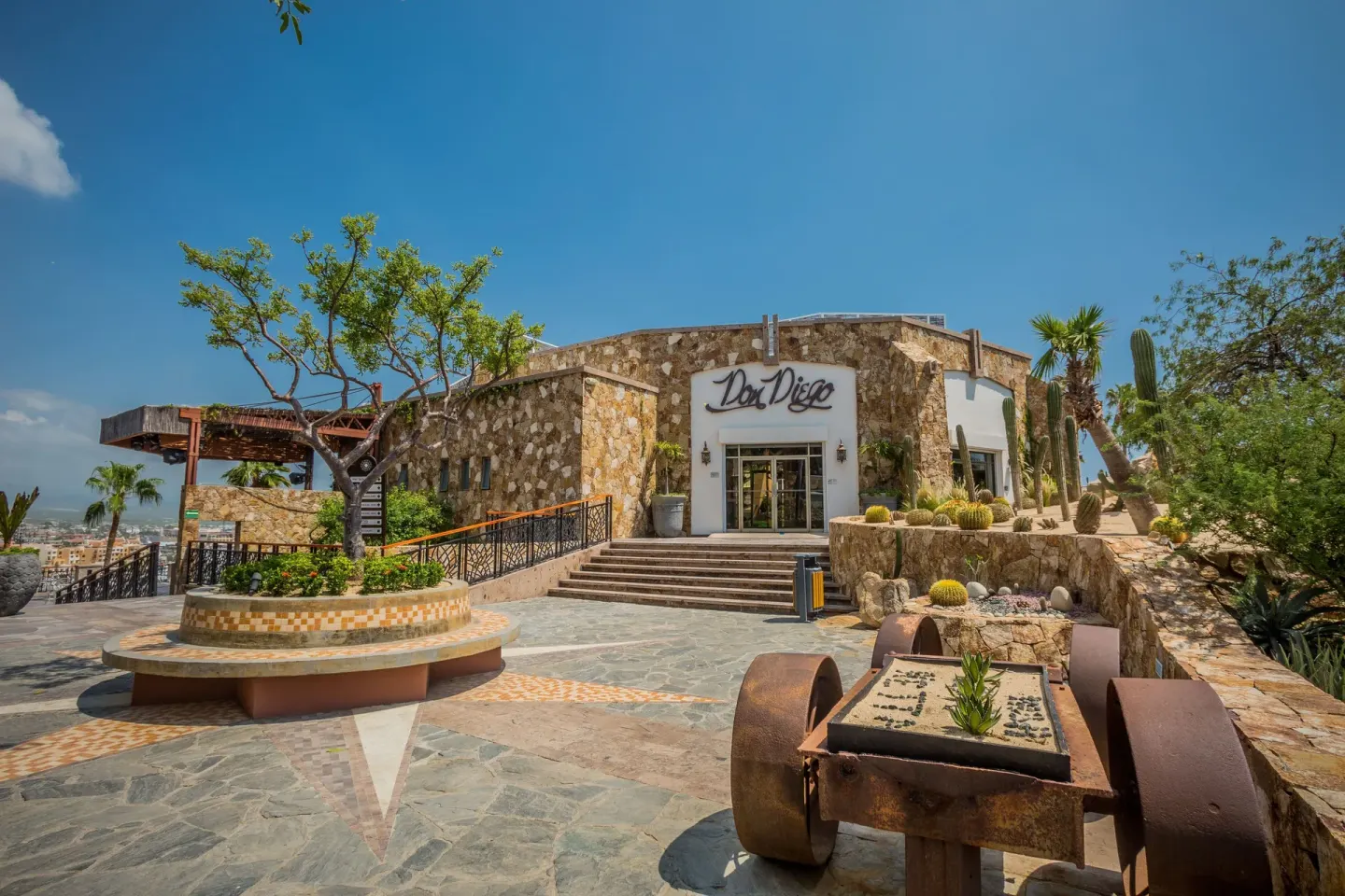 Don Diego entrance with stone walls, steps, cactus landscaping and clear sky at Sandos Finisterra.