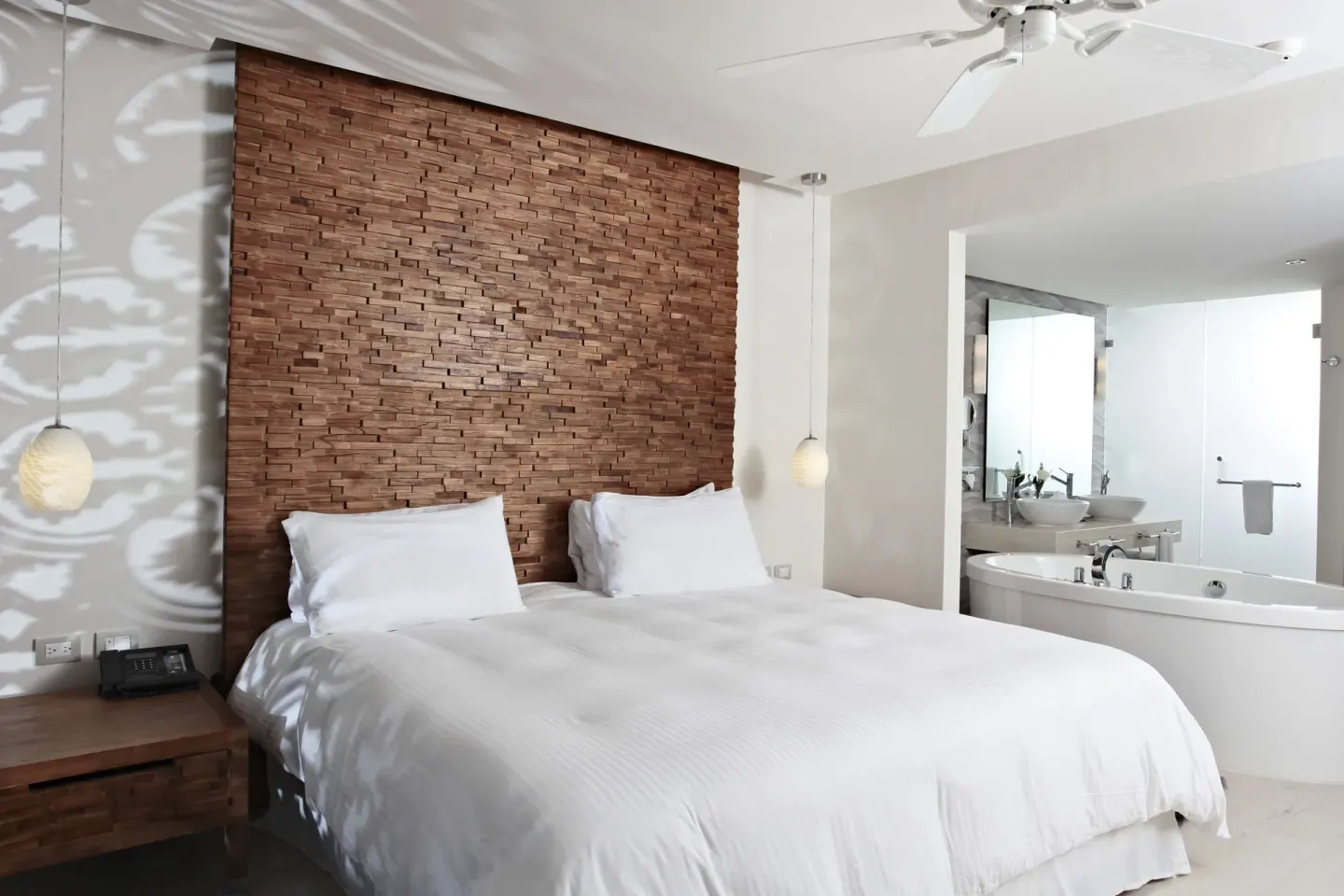 Finisterra Suite king bed beside a soaking tub and vanity at Sandos Finisterra.