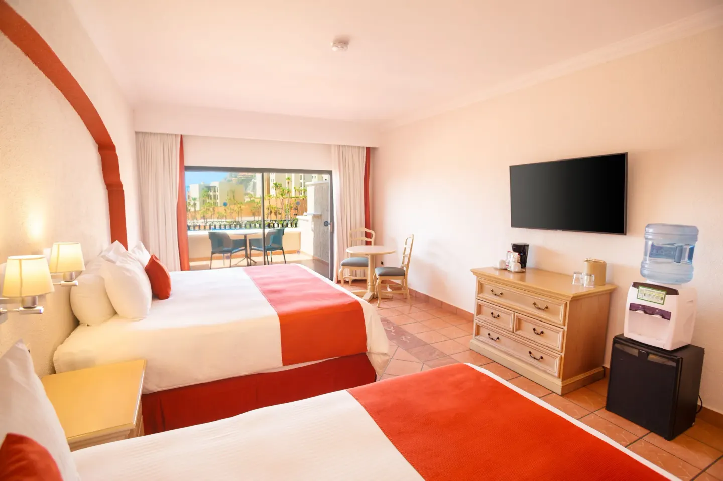 Junior Suite Garden View with two beds, balcony, TV, dresser and water dispenser at Sandos Finisterra.
