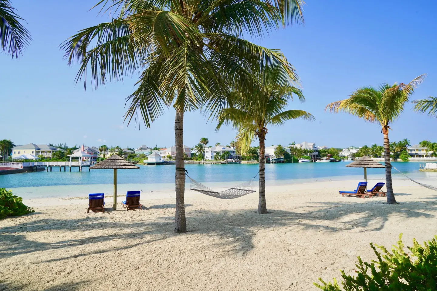 Sandy beach with hammocks, palms and lagoon views at Sandyport Beach Resort.