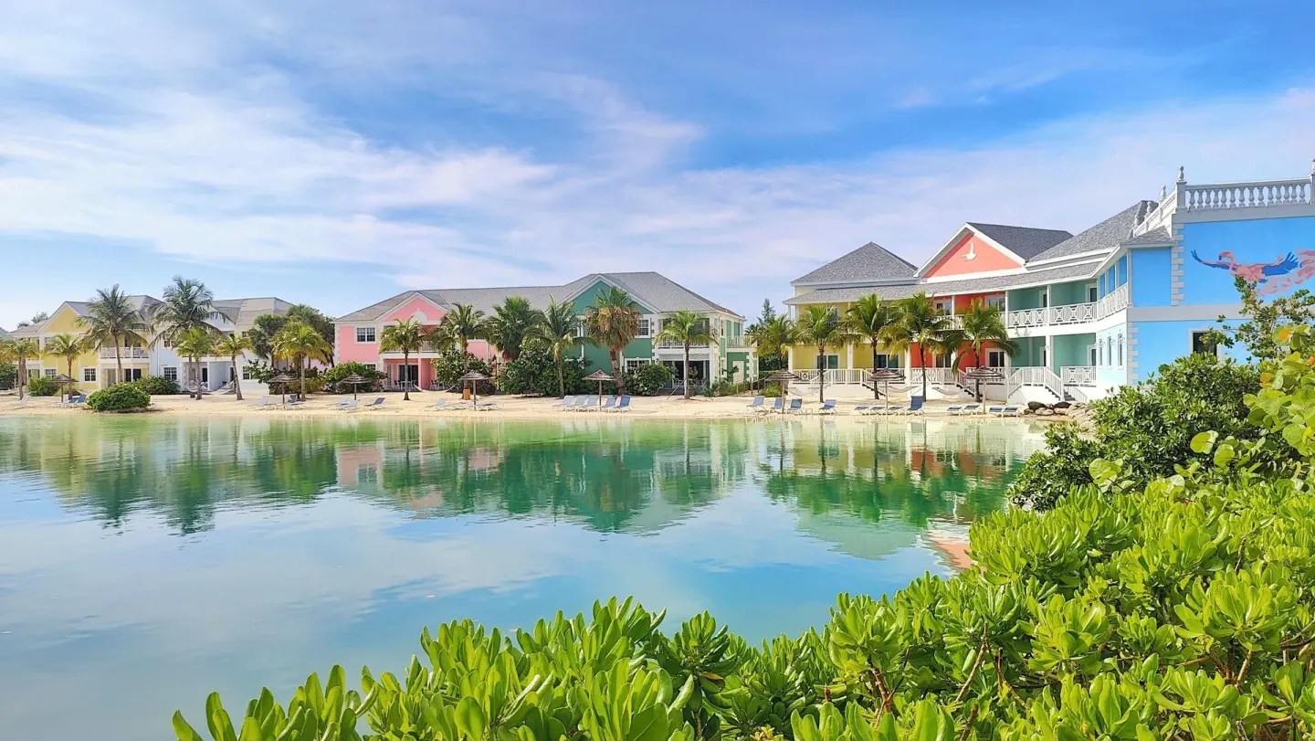 Pastel resort buildings reflect in the lagoon at Sandyport Beach Resort.