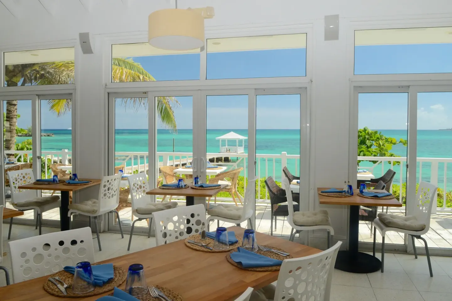 Bright dining room with ocean-facing windows at Sandyport Beach Resort.