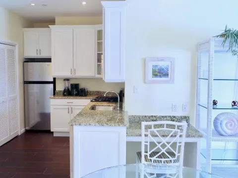 Deluxe suite kitchen with refrigerator and granite counter at Sandyport Beach Resort.
