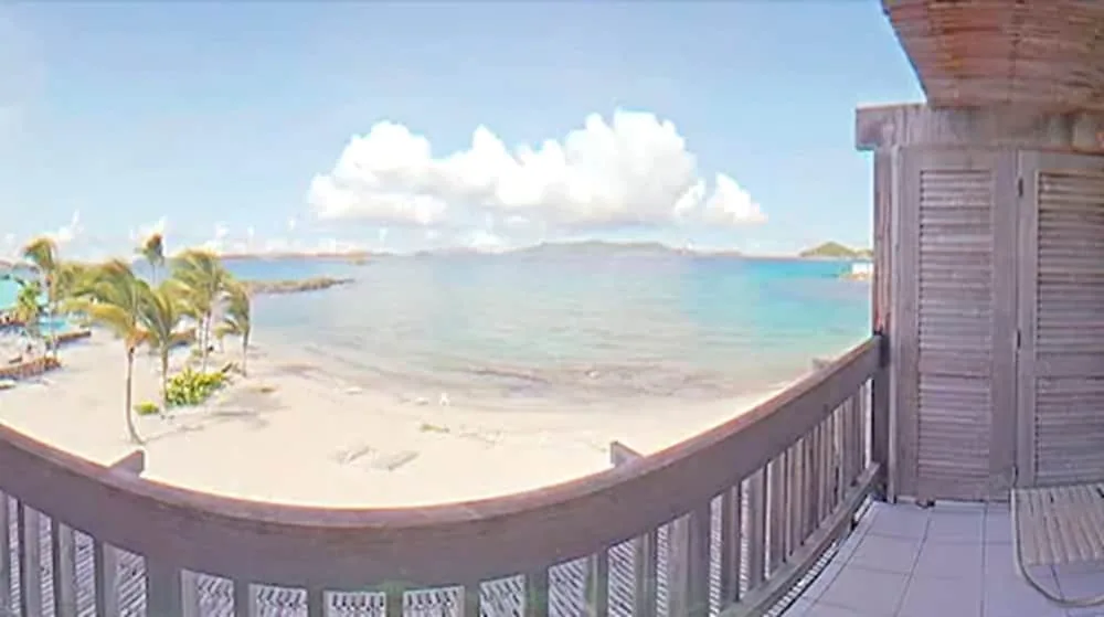 Beachfront balcony view of turquoise water and sand at Sapphire Beach Resort.