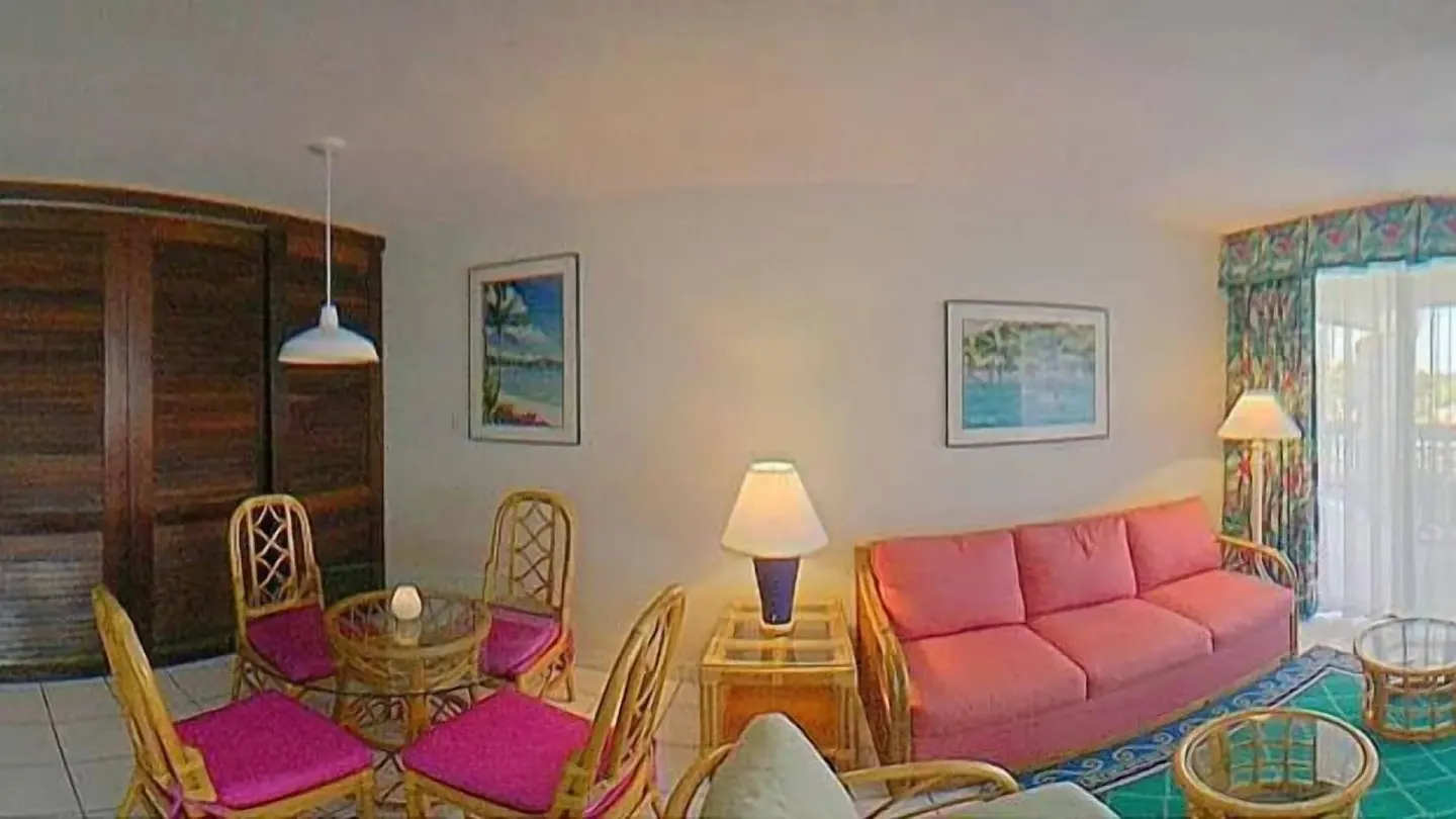 Living and dining area with rattan furniture at Sapphire Beach Resort.