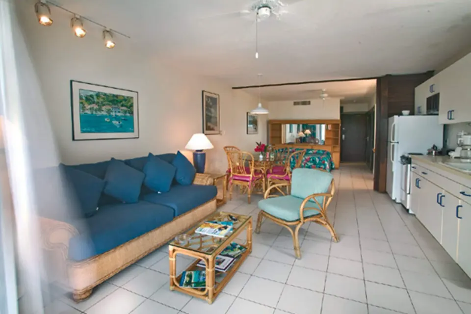 Standard Studio Suite living area with sofa bed, kitchenette, dining set, and bed at Sapphire Beach Resort.