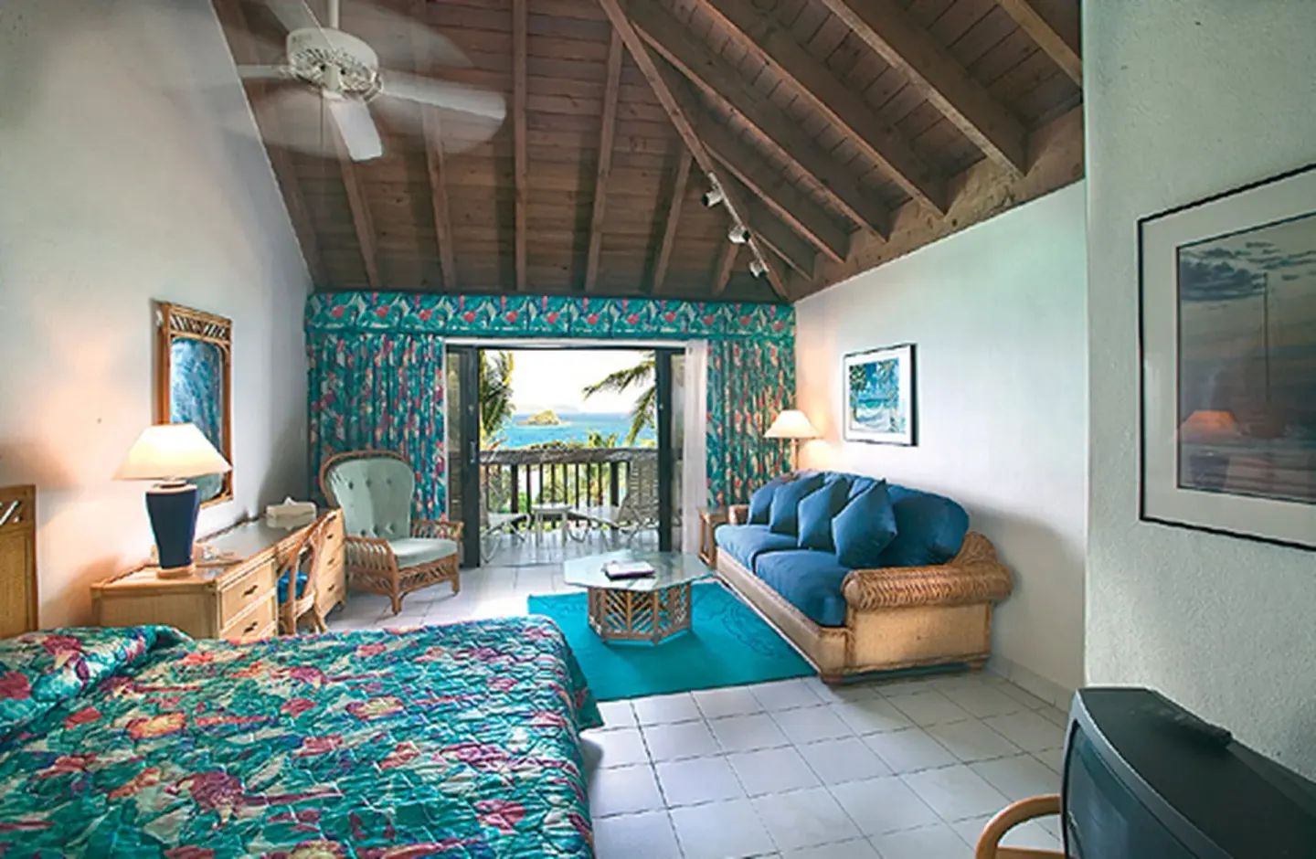 Beachfront villa bedroom and sitting area with balcony at Sapphire Beach Resort.
