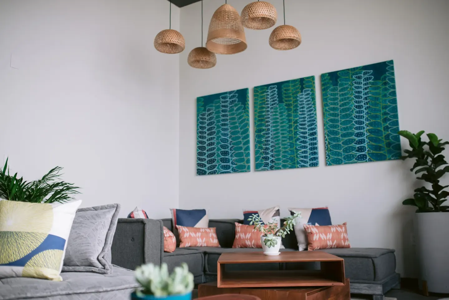 Lobby lounge with sofas, woven pendant lights, and wall art at SCP Hilo Hotel.