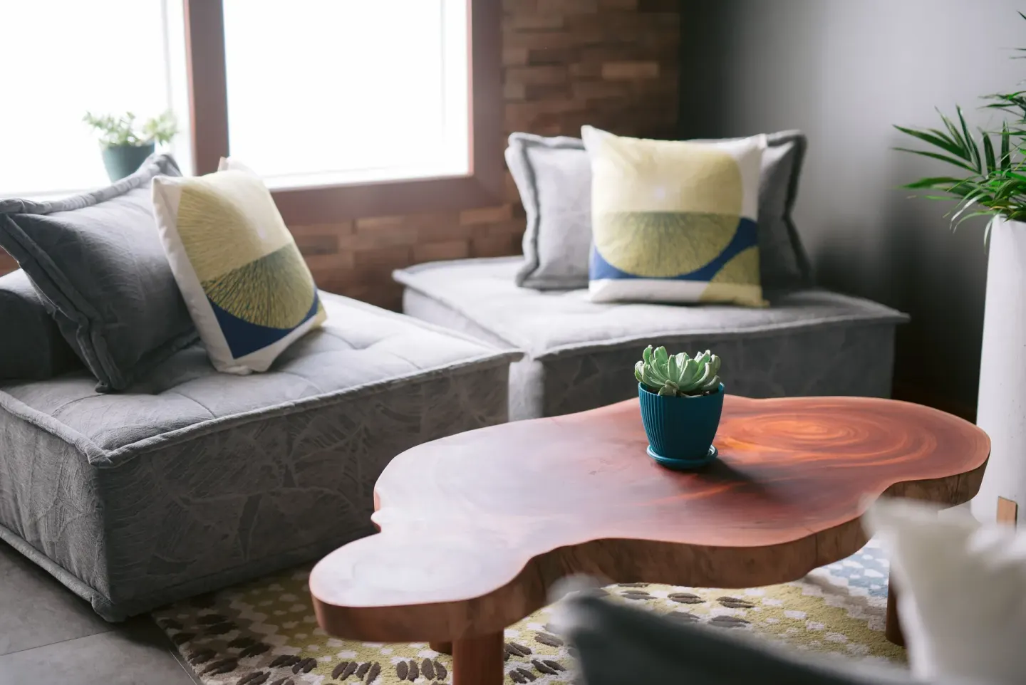 Lounge seating with gray cushions and a wood coffee table at SCP Hilo Hotel.