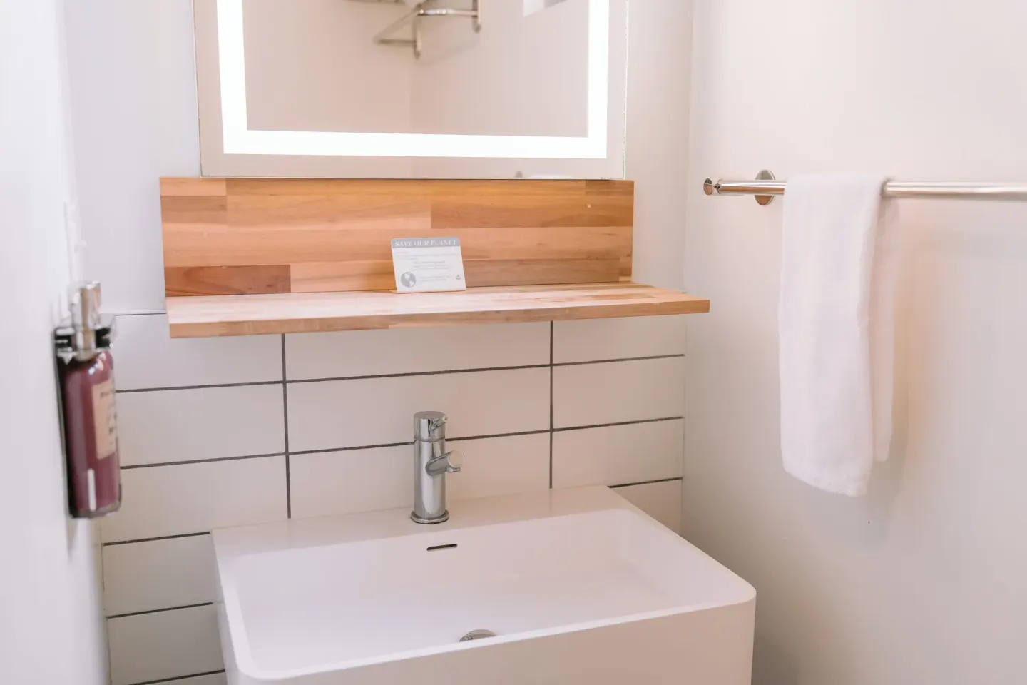 Peaceful Room bathroom sink with mirror and towel at SCP Hilo Hotel.