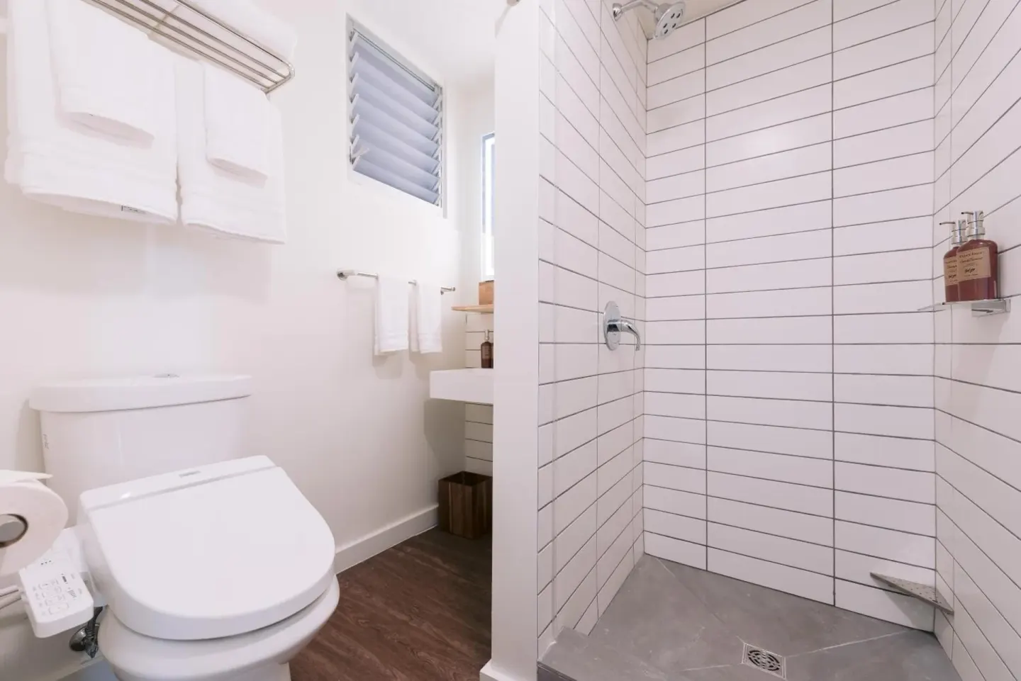 Peaceful Room bathroom with toilet and walk-in tiled shower at SCP Hilo Hotel.