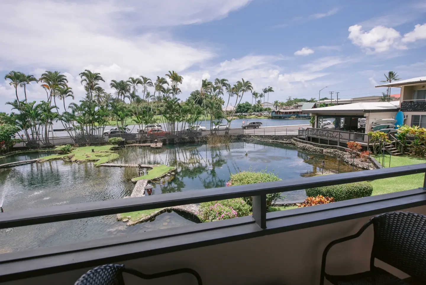 Balcony view over ponds, palms, and Hilo Bay from a room at SCP Hilo Hotel.